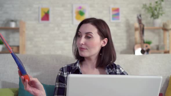 Young Woman Using Laptop and Searches the Internet for Information About Orthopedic Insoles