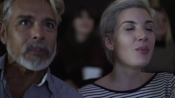 Smiling couple watching movie in theatre