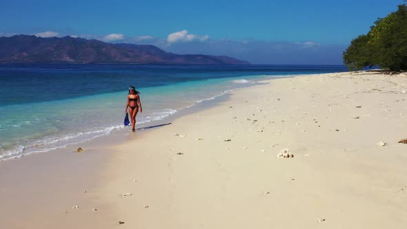 Beautiful women posing on tranquil seashore beach wildlife by blue green sea and white sand backgrou