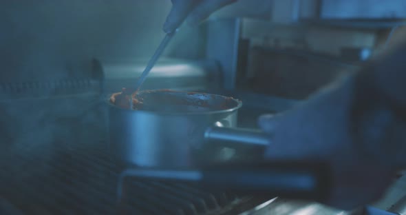 Hands of professional chef stirring meal