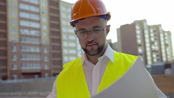 Man Looks in White Paper with House Project