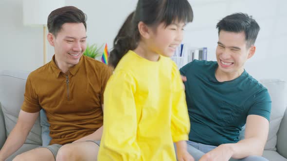 Portrait of handsome man gay family with young daughter in living room.