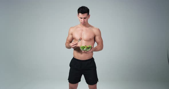 A Male Fitness Model Holding a Plastic Bowl and