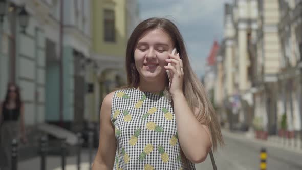 Cute Young Woman Walking Around the Old European City, Talking on the Phone