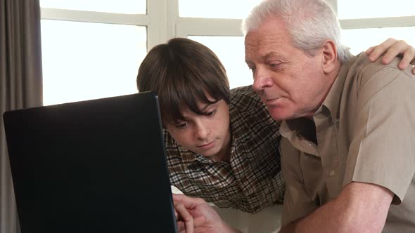 Little Boy Helping His Grandpa with Laptop