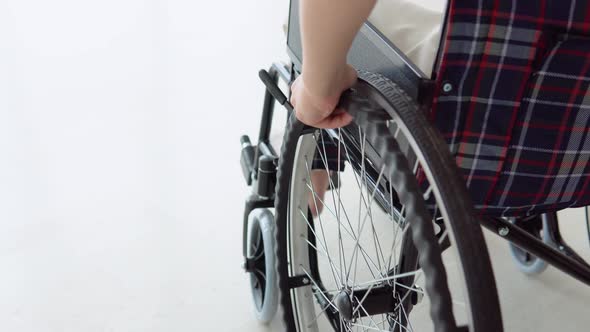 Close Up of Woman's Hand Moving Wheelchair Indoors at Home