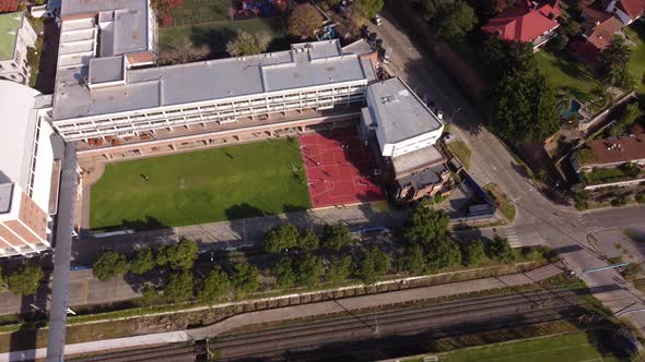 Aerial drone circling view of school sport area with football and basketball fields in Buenos Aires,