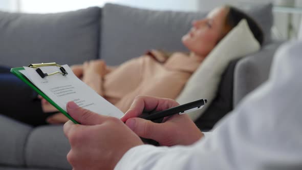 Close Up Man Psychotherapist Taking Notes on Clipboard and Listen Woman Patient