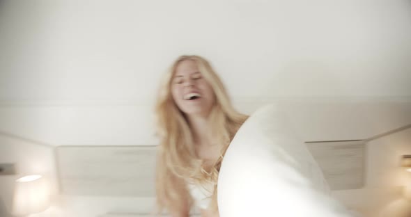 Playful Young Adult Having Fun and Laughing During a Pillow Fight