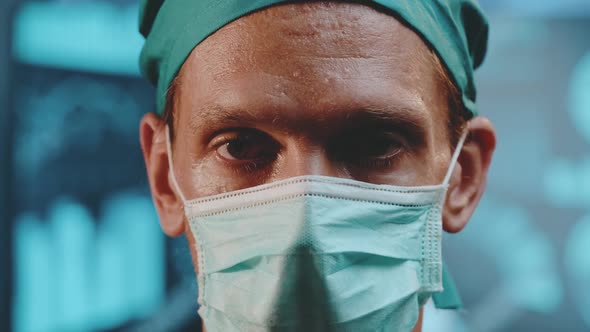 Portrait of a tired doctor wearing a surgical cap and a protective mask