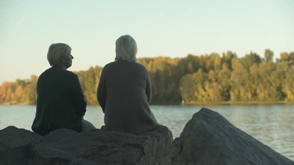 Two Senior Women Sitting in Park Near Lake and Talking, Best Time With Friend