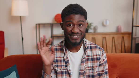 Man Sitting on Home Sofa Looking at Camera Making Video Conference Call with Friends or Parents