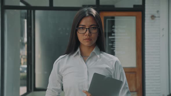 Beautiful Young Woman Walks at Business Downtown in Morning Holding Laptop in Hands