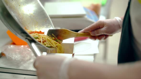CU: Cook Shifts the Noodles with Vegetables Into the Package.