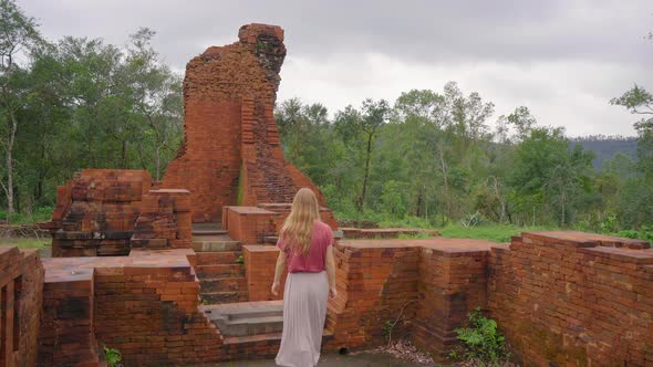 A Young Woman Tourist Is Walking Through Ruins in the My Son Sanctuary Remains of an Ancient Cham
