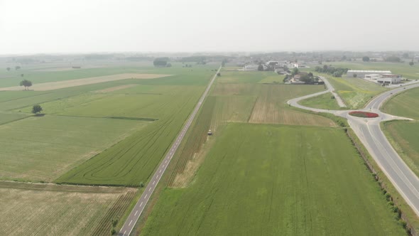 Aerial: tractor working on cultivated fields farmland, agriculture occupation, top down view
