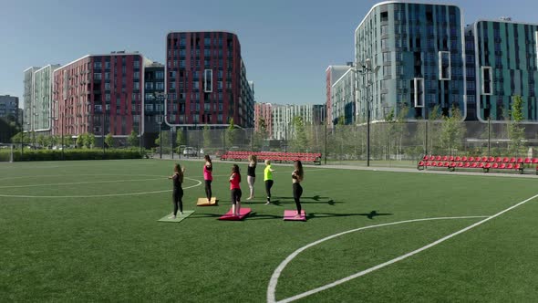 Girls doing yoga on the sports ground 