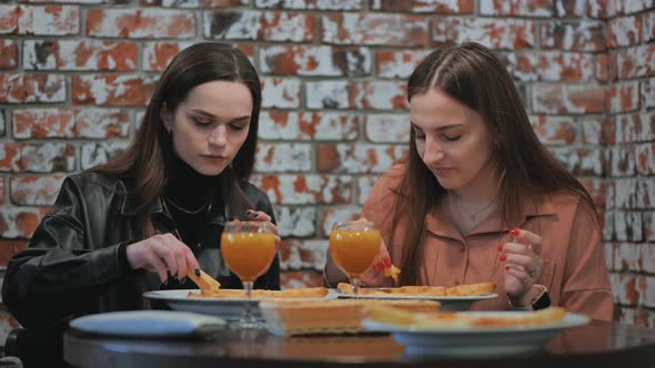 Young Girls Eat in a Cafe and Talk