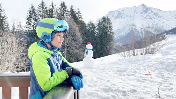 Boy on Pose at Balcony Smile in Ski Outfit Glasses and Helmet