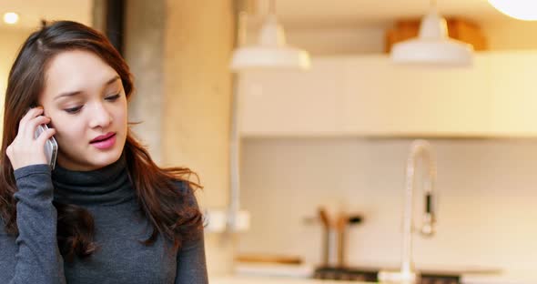 Woman talking on mobile phone in living room