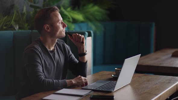 Thoughtful Serious Young Man Student Writer Sit at Home Office Desk with Laptop Thinking of