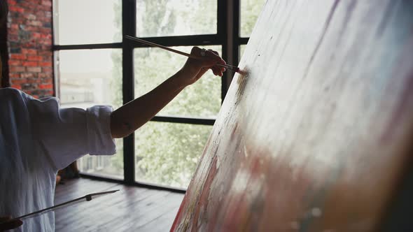 Hand of Unknown Woman Artist Who Drawing a Portrait on Canvas in Modern Art Style Against Huge