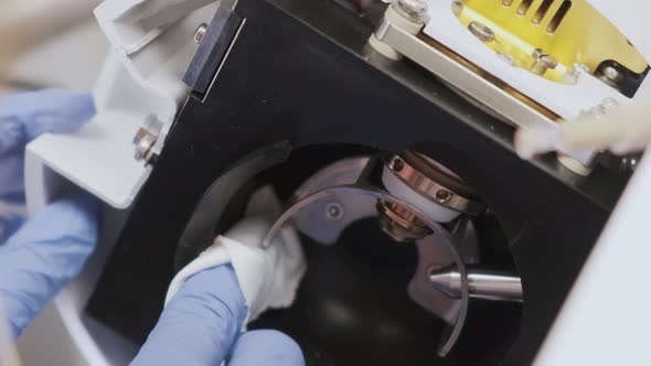 Close Up Scientist Cleaning an Ion Source of Mass Spectrometer with Lint Free Cloth and Solvent