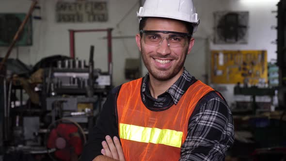 Handsome male caucasian engineer or worker, coss arms, smile, and blink