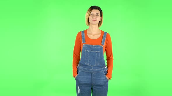 Woman Standing and Looks at the Camera. Green Screen