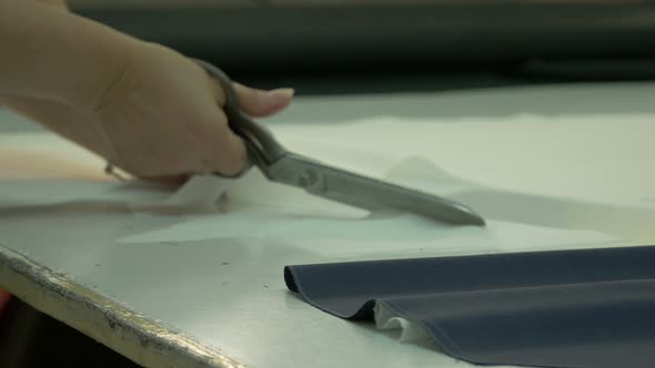 Seamstress' hands cutting a fabric