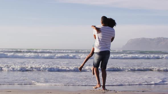 African american father and his daughter playing on the beach