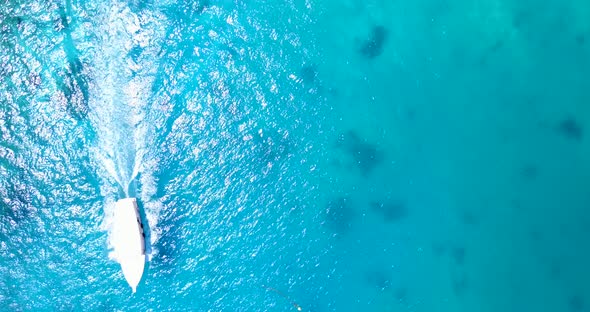 Daytime flying abstract view of a sunshine white sandy paradise beach and aqua blue water background