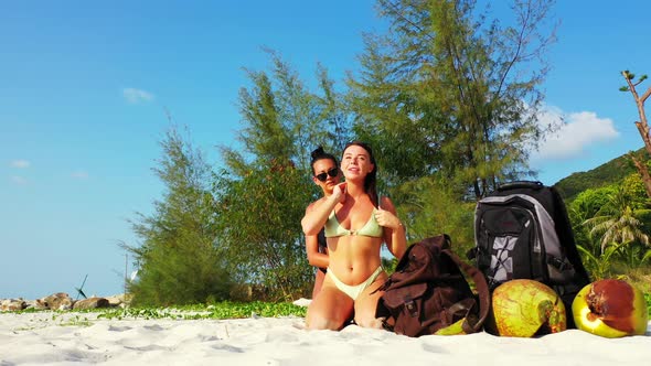 Young Smiling Ladies Relaxing Having Fun on Beach on Paradise White Sand and Blue