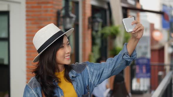 Young Asian woman using smartphones take photos around community malls.