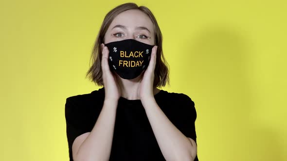 Woman in face mask with Black Friday shopping bags in hands. Sale during pandemic