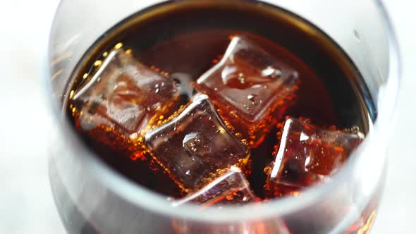 Soft Drinks in a Glass with Ice Cube on White