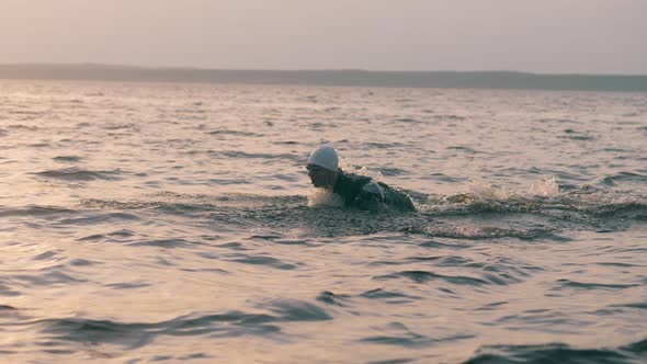 A Man in Swimwear Is Swimming Along the Sea Waves