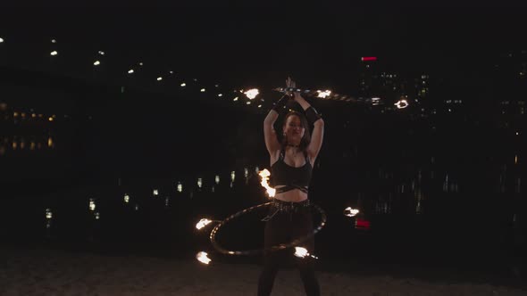 Redhead Firegirl Twisting Fire Hoops at Dusk