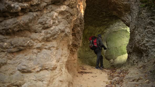 Small Cave Exploring by Caucasian Hiker in His 30s.