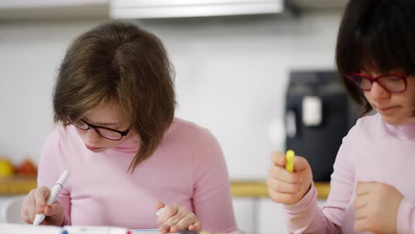 Portrait of Two Girls Draw with Colorful Pens at Home Close Up