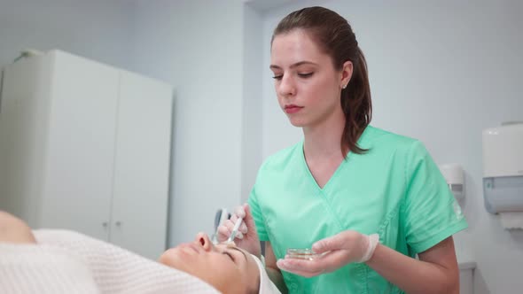 Female Beautician Makes Face Rejuvenation and Cleansing Procedure for Girl