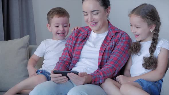 Happy Family,mom and Cute Little Children Watch the Phone,mom Plays with Children at Home,relaxing