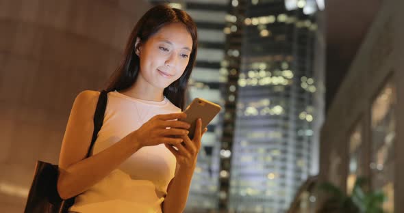 Woman using cellphone at night 