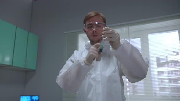 Scientist in Protective Workwear Shake Tube with Liquid and Shiff It in the Laboratory