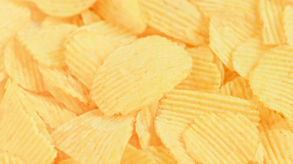 Looped Spinning Yellow Wavy Potato Chips Full Frame Closeup Background