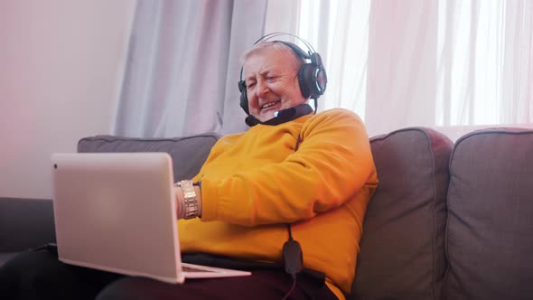 Happy Elderly Man with Headset Having Video Call with Family