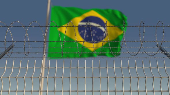 Barbed Wire Against Waving Flag of Brazil
