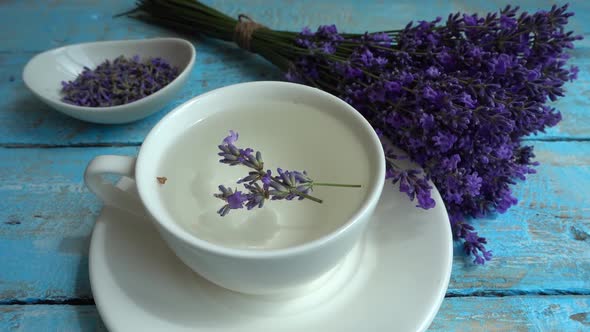 Tea from fresh lavender flowers on a vintage wooden background