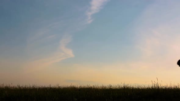 Silhouette of Boy at Sunset. The Boy Runs From One Side To the Other on a Summer Evening.