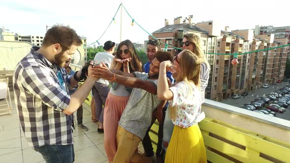 Group of people taking photos while musician playing guitar on rooftop terrace